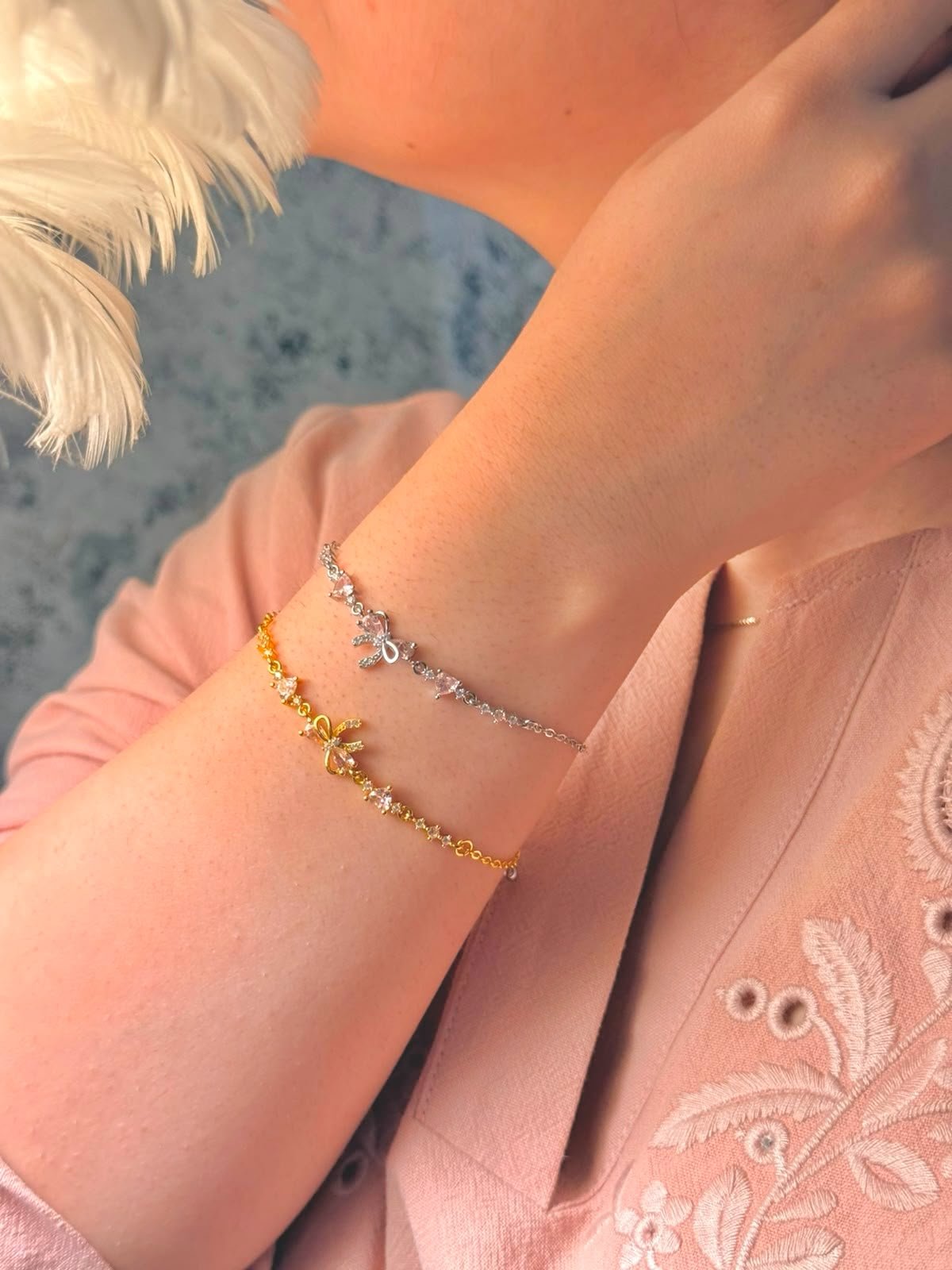 Gold and silver Bow Bracelets stacked together on a wrist