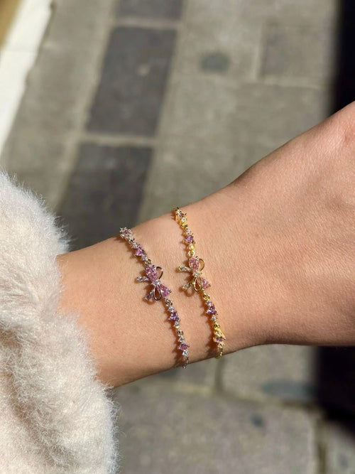 Gold and silver Bow Bracelets worn together in daylight