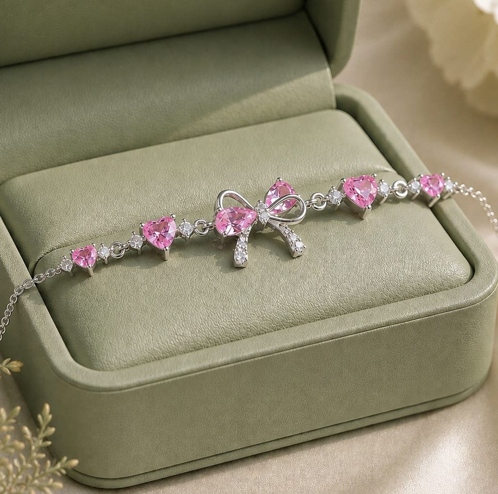 FairyLiora Bow Bracelet in silver with pink heart cubic zirconia stones, presented in a sage green gift box