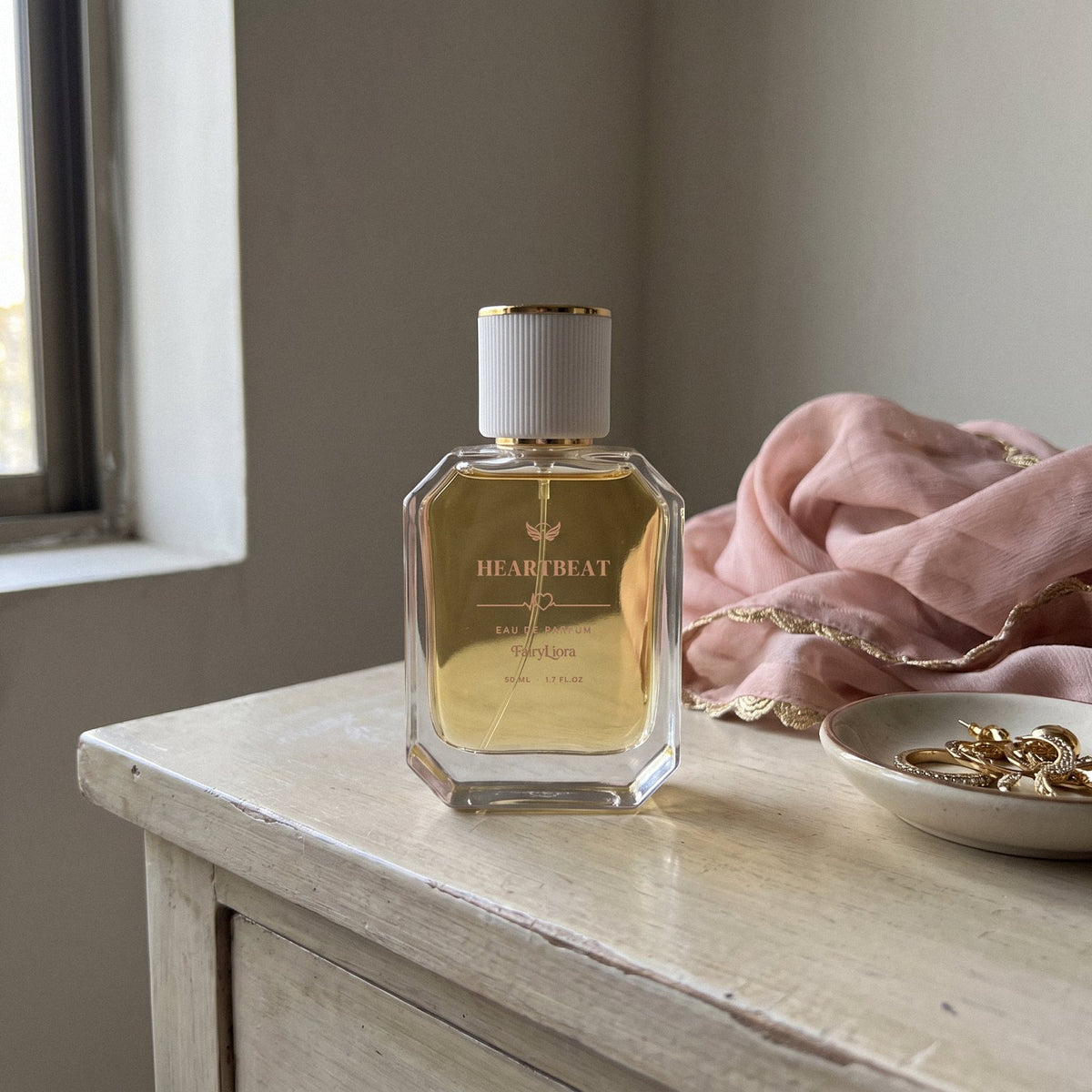 Heartbeat perfume on a wooden dressing table with a blush dupatta