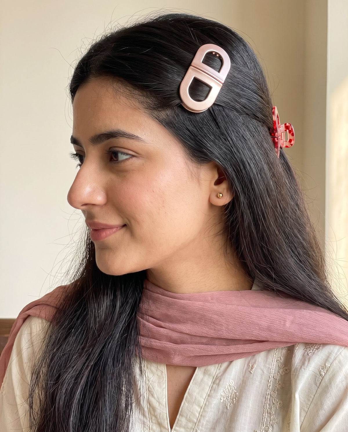 Rose gold and cherry clips worn one on each side, ivory kurta and pink dupatta