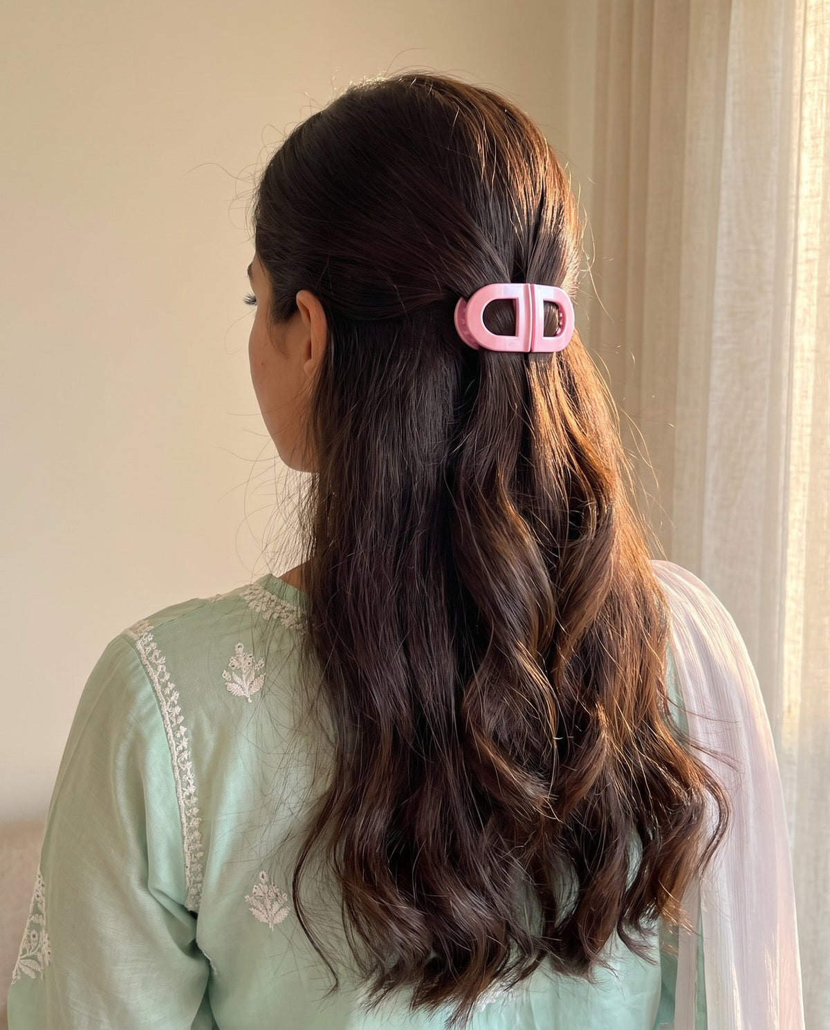 Pink Pop clip holding a half-up in long dark wavy hair, mint chikankari kurta