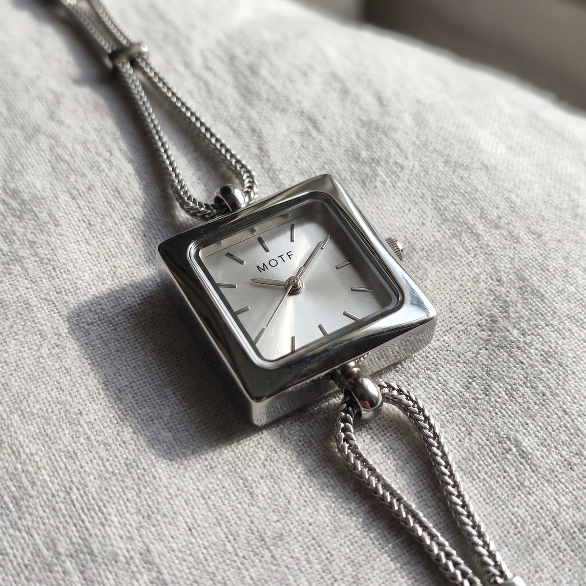Queen's Watch silver sunburst dial and foxtail chain close-up