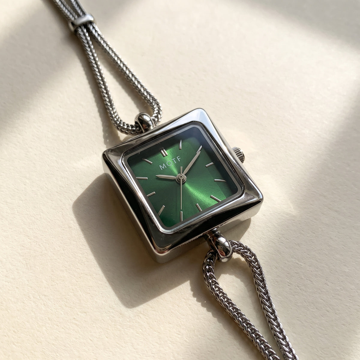 Queen's Watch green sunburst dial and foxtail chain close-up
